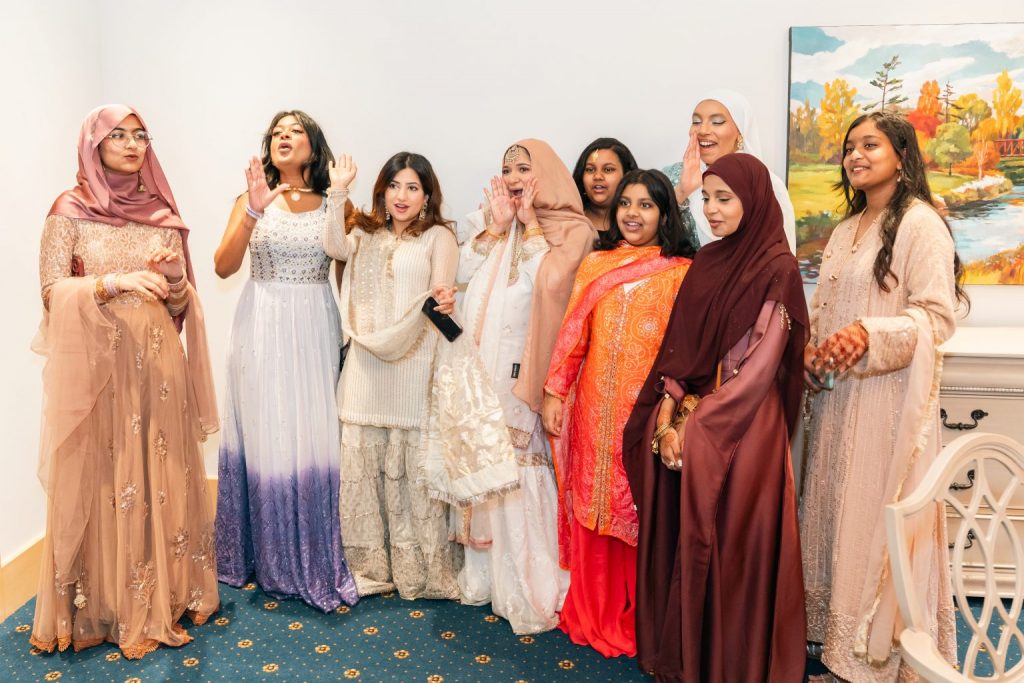 Group of women in traditional dresses celebrating indoors